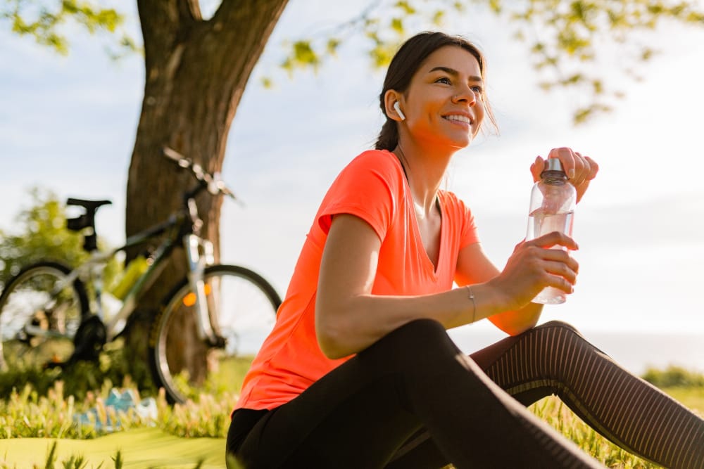 smiling-beautiful-woman-drinking-water-bottle-doing-sports-morning-park